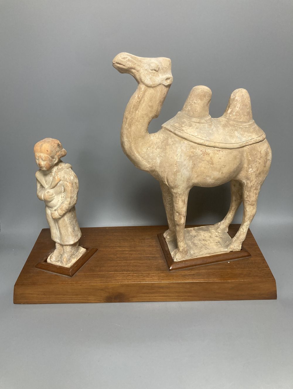 A group of Chinese Tang style pottery figures, tallest 28cm and a partially glazed ewer in sancai colours against a blue ground, 40cm